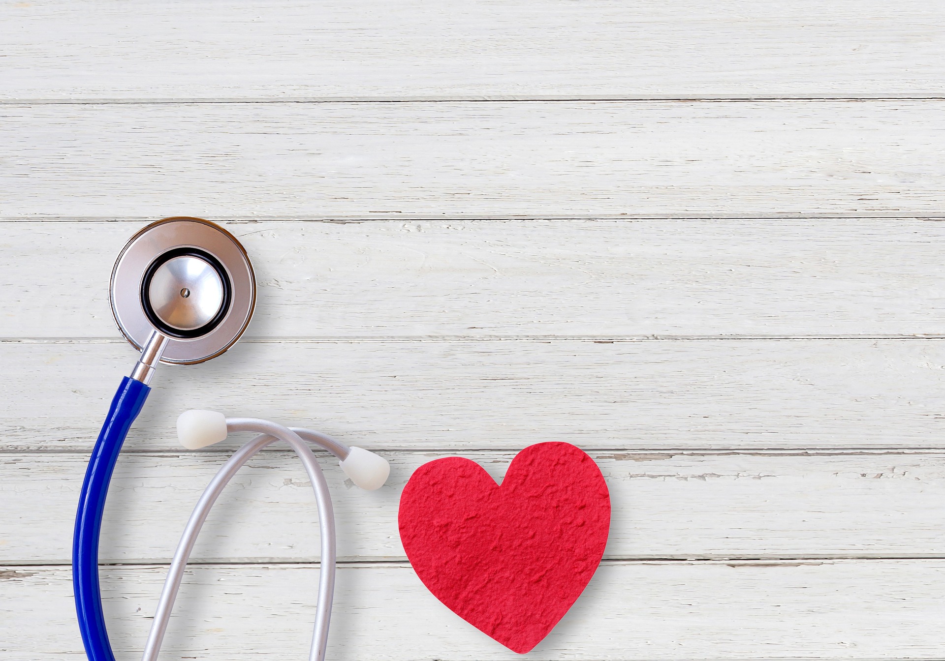 stethoscope and heart on wood background