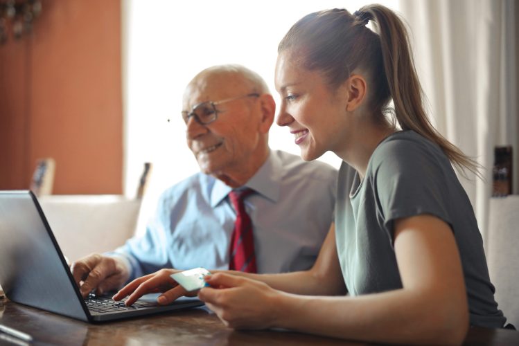 Girl helping older man with computer
